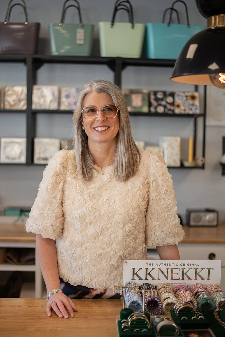 Sara står bakom butikens disk på Stilfullt i Falköping, omgiven av noga utvalda smycken och accessoarer.