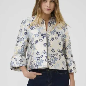 Kvinna bär en blommig jacka i skimrande jacquard med trumpetärmar och rak passform, från Culture.