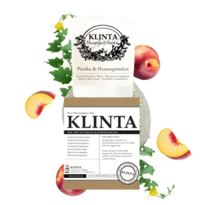 Klinta massageljus Persika & Honungsmelon med tillhörande förpackning, dekorerat med persikobitar och melon i bakgrunden.
