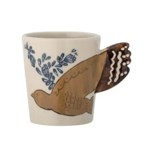 Beige stengodsmugg från Bloomingville med handmålat fågelmotiv i brunt och blått samt ett handtag format som fågelstjärt, fotograferad mot vit bakgrund.