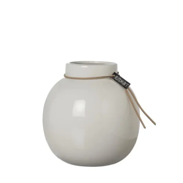Vit rund glasvas från Ernst med läderband och logotypbricka, stående mot vit bakgrund.