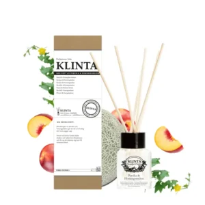 Klinta doftpinnar Persika & Honungsmelon med glasflaska, träpinnar och kartong, omgiven av melon, persikobitar och blad.