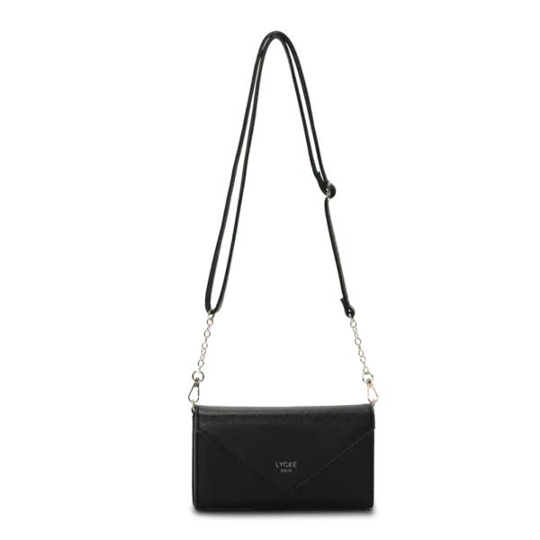 Svart flap bag i kuvertmodell med silverkedja och justerbar rem, från Lycke Oslo – hänger fritt mot ljus bakgrund.