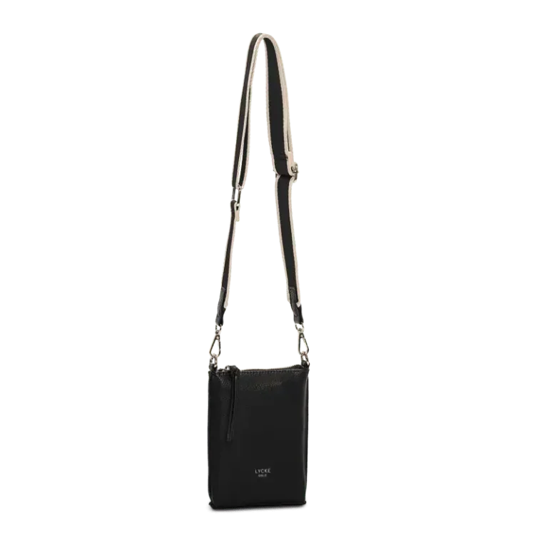 Svart phonebag med justerbar axelrem och präglad logotyp från Lycke Oslo, hängande mot en neutral bakgrund.