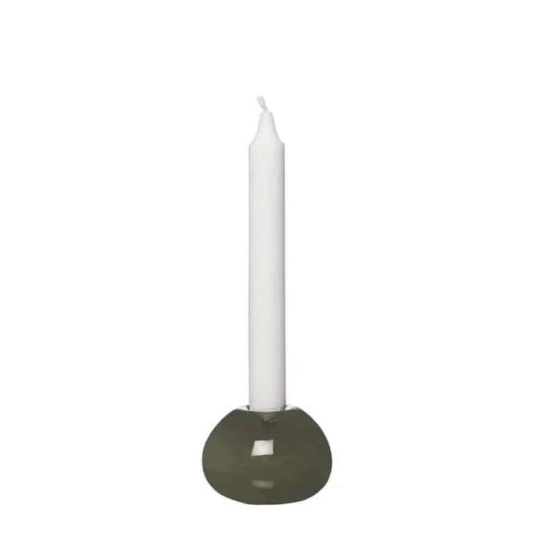 Grön glasklotformad ljusstake med vitt stearinljus, designad av ERNST, mot vit bakgrund.