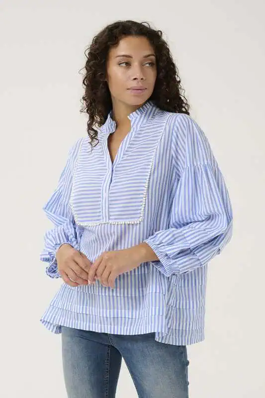 Kvinna i blå- och vitrandig CUjax Blouse från Culture med avslappnad passform och pärldekorerat bröstparti.
