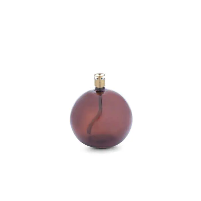 Oljelampa i rund form med cognacsfärgat glas och mässingsfärgad brännare, modell Round Cognac Brass S från Peri Design.