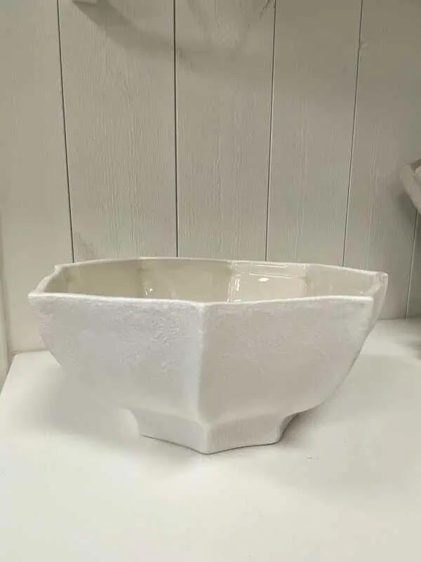 Stor skål i naturvit keramik med skulpturala linjer och blank insida, från ERNST, fotograferad mot ljus bakgrund.