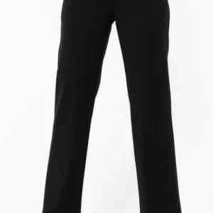 Kvinna bär svarta Manhattan-byxor från Capri Collection med rak passform och klackskor, fotograferad mot vit bakgrund.