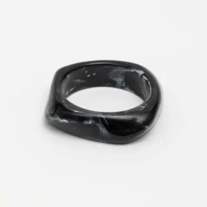 Svart armband i resin med fyrkantig utsida och rundad insida, fotat ovanifrån på vit bakgrund.