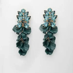 Ett par gröna örhängen med glittrande zirkonstenar och formade akrylblad.