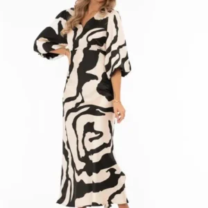 Mönstrad satinklänning i champagne och svart med V-ringning och puffärmar från Capri Collection.