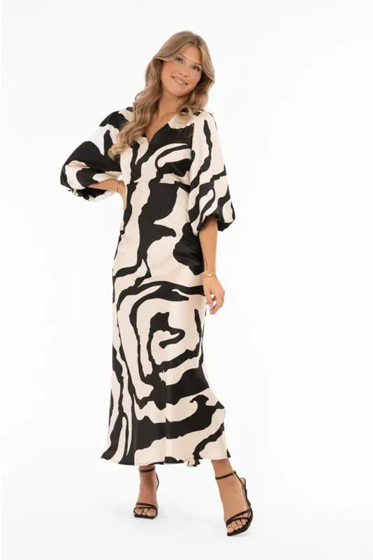 Mönstrad satinklänning i champagne och svart med V-ringning och puffärmar från Capri Collection.