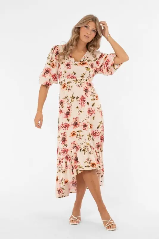 Aveline blommig klänning från Capri Collection i creme och rose med v-ringning och volangkjol.