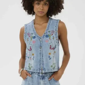 Modell bär ljus jeansväst från Culture med broderade blommor och v-ringning tillsammans med matchande jeans.