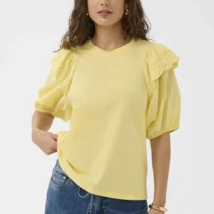 Modell bär gul t-shirt från Culture med puffärmar och rund hals tillsammans med jeans.