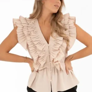 Modell bär champagnefärgad blus från Capri Collection med volanger, v-ringning och peplumformad nederdel.