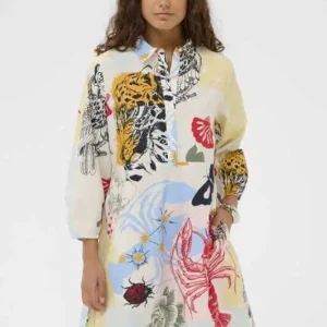 Modell bär kort mönstrad klänning från Culture i blått och rött med långa ärmar och avslappnad passform.