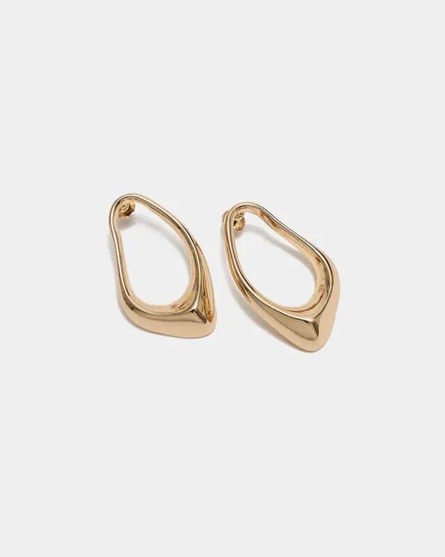 Cia Earrings från BOW19 i guldfärgad metall med asymmetrisk ihålig design.