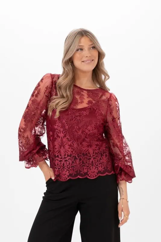 Amandine Blouse Ruby Red från Capri Collection, rubinröd blommig spetsblus med puffärmar och vågformade spetskanter.