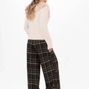 Vida Catriona Pants från Capri Collection i ett klassiskt rutmönster med svart botten och linjer i bruna och sandfärgade toner, stylade med svarta boots.