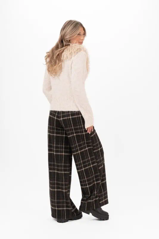 Vida Catriona Pants från Capri Collection i ett klassiskt rutmönster med svart botten och linjer i bruna och sandfärgade toner, stylade med svarta boots.