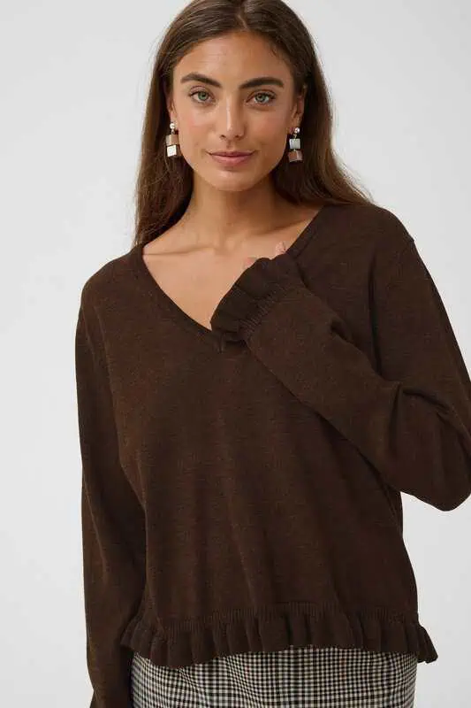 Modell i brun CUclare Annemarie Frill Vneck från Culture, en V-ringad stickad tröja med långa ärmar, volangdetaljer och ribbstickad nederkant.