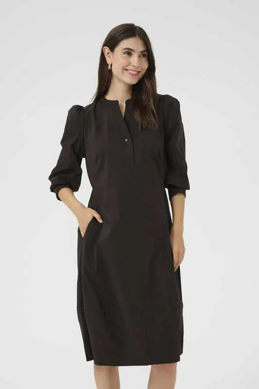 Modell i svart CUAntoinett 3/4 Sleeve Dress från Culture med puffade trekvartsärmar, knappslå vid halsen och sidfickor.